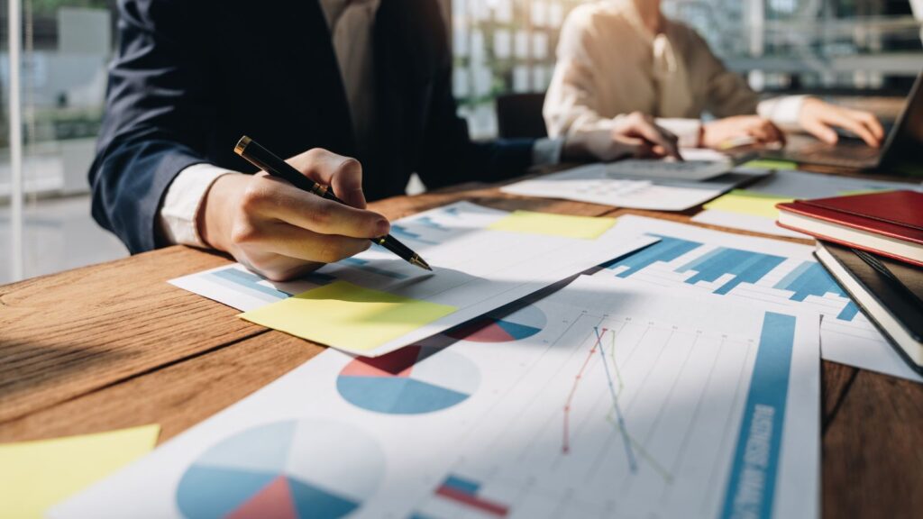 Business team reviewing charts, graphs, and financial reports during a consulting meeting to plan strategy and improve performance.