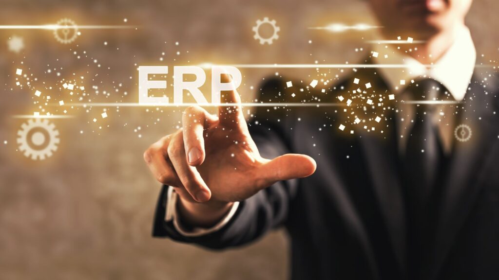 Businessperson pointing at glowing 'ERP' text with digital gear icons, symbolizing modern enterprise resource planning technology.